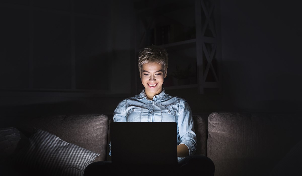 woman sitting on sofa surfing web