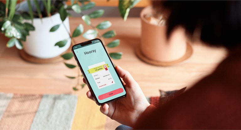 A person is holding a smartphone and viewing a screen with the title "The Sky's the limit!"