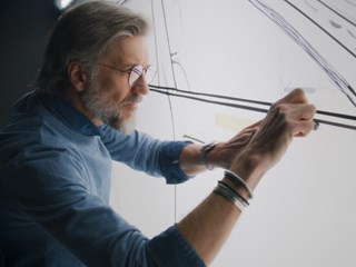 Experienced designer drawing on a whiteboard, conceptualizing innovative design ideas.