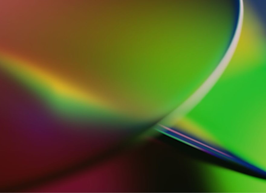 An abstract image featuring a smooth blend of vibrant colors, including green, yellow, purple, and red. The colors transition seamlessly, creating a gradient effect with soft, curved lines. The design has a dynamic, fluid feel, evoking a sense of motion and energy. The image is visually striking, with a modern and futuristic aesthetic, suitable for representing innovation or creative concepts.