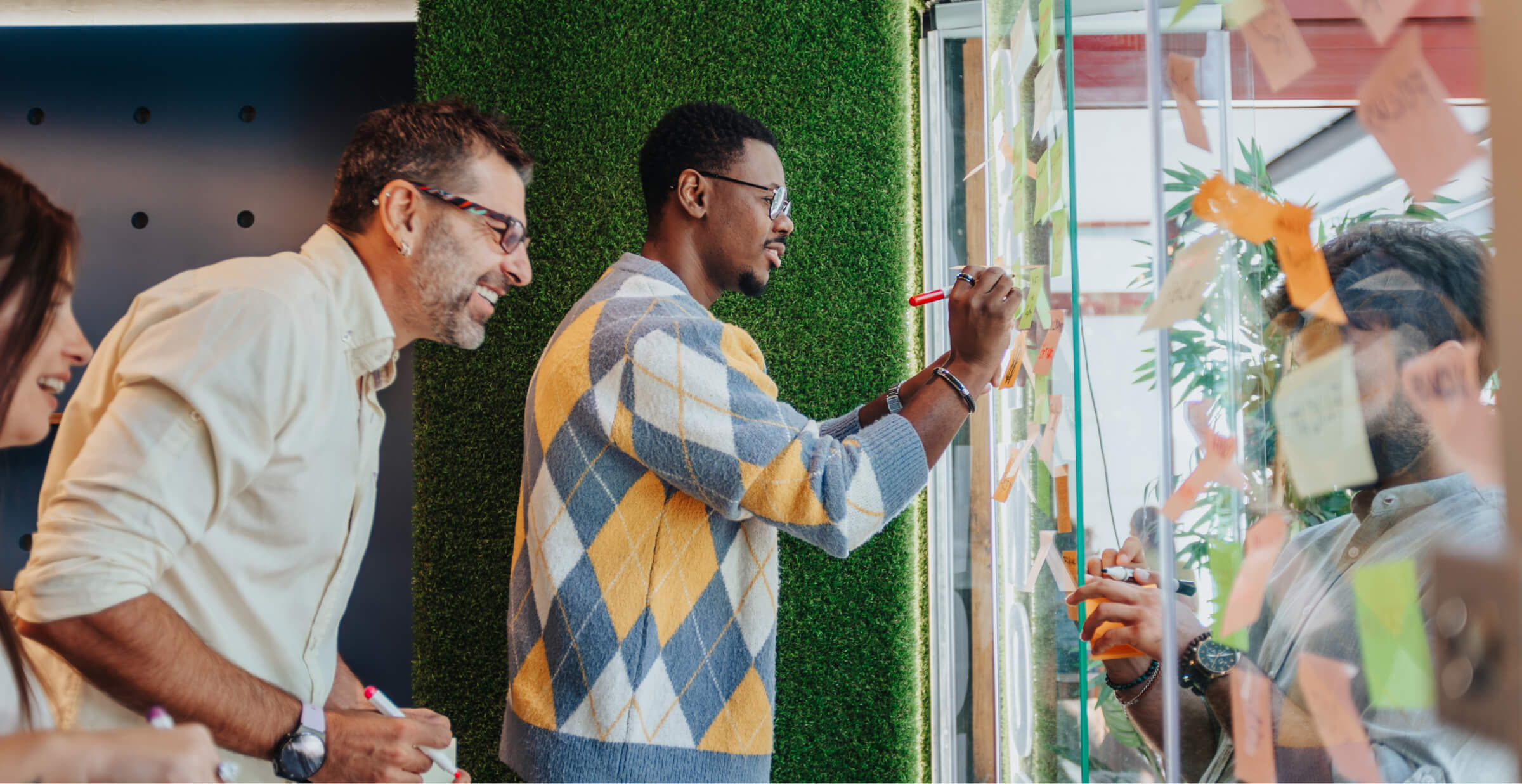 Diverse team collaborating on a project using sticky notes and markers in a creative workspace.