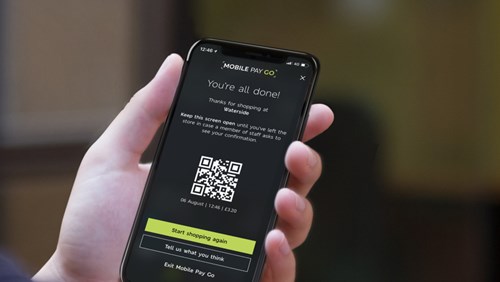 A person is holding a smartphone that displays the final screen of the "Mobile Pay Go" app, confirming that the shopping process is complete.
