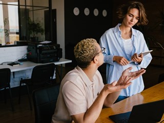 Two coworkes in conversation.