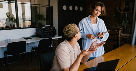 Two coworkes in conversation.
