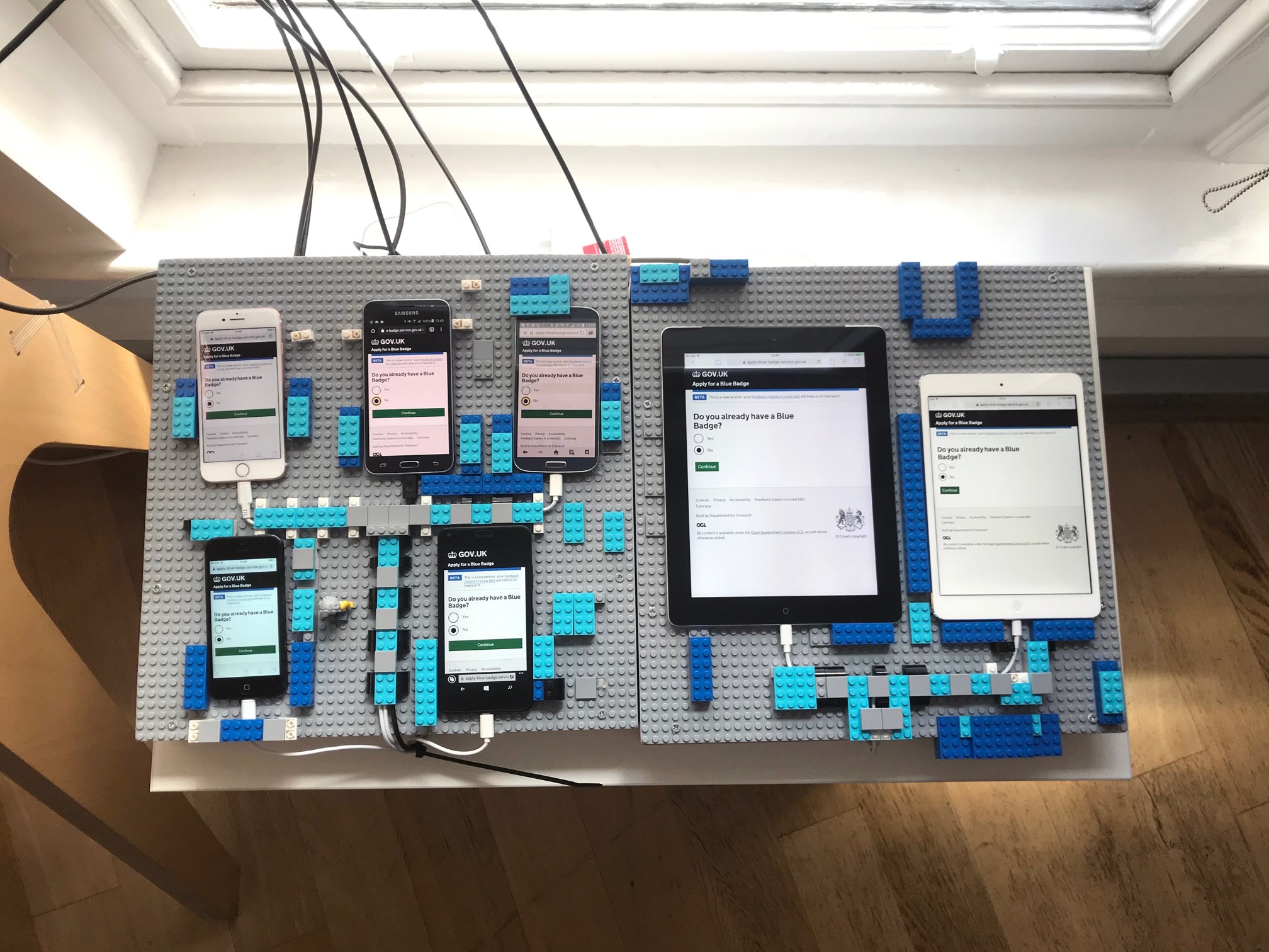The Blue Badge Digital Transformation team&rsquo;s device lab in Manchester. The lab consists of: Windows Mobile, Samsung Galaxy S4, Samsung Galaxy S5, iPad mini, iPad, iPhone 5, iPhone 6 and a Dell laptop. The iOS devices come with Voice Over screen reader, and the laptop has JAWS 2018 and Nuance Dragon 15 installed