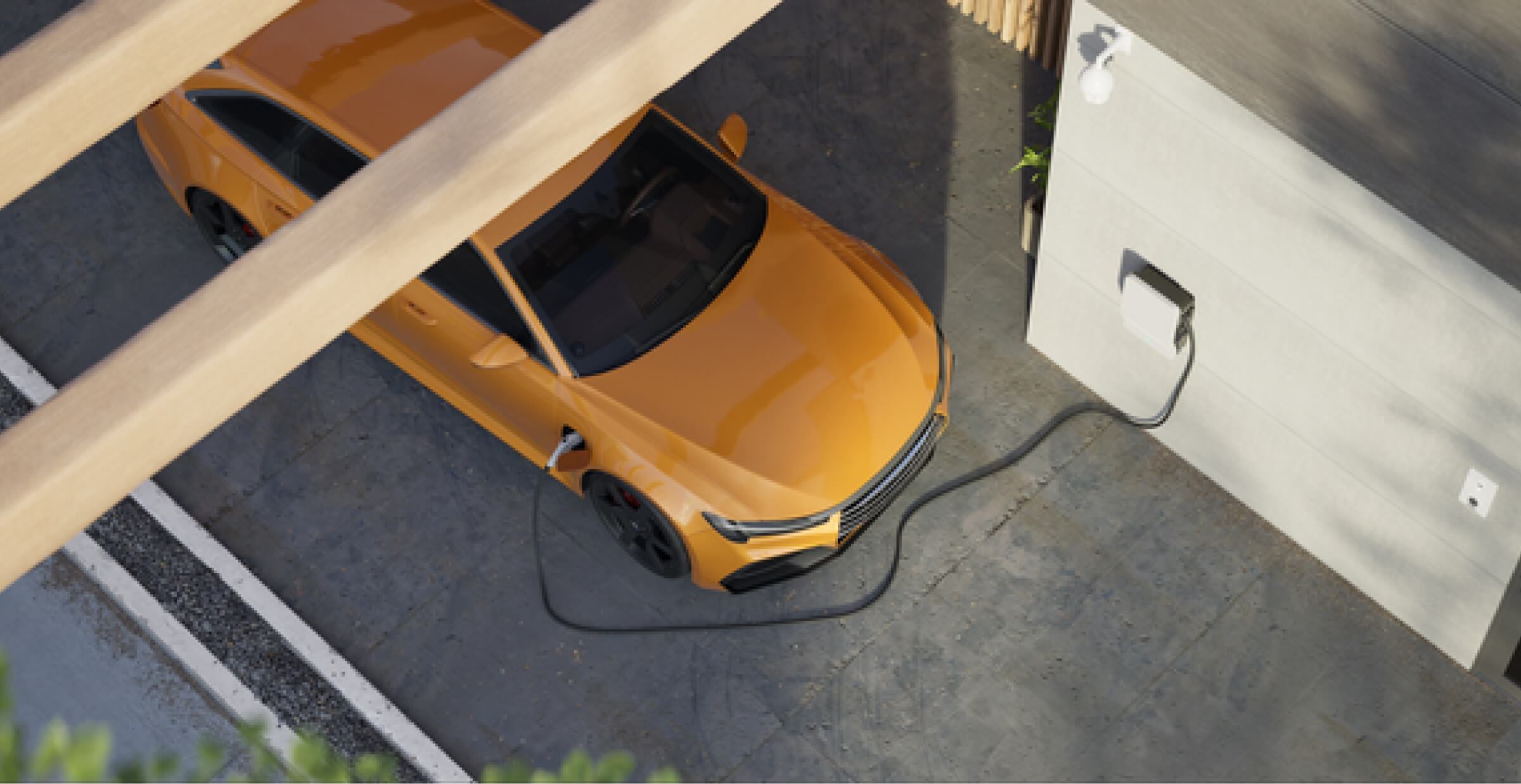 A top-down view of an orange electric car charging at a home charging station. The car is parked in a driveway, connected to a wall-mounted charging unit. The setting is modern and clean, with part of the car shaded by a wooden structure. The image highlights sustainability and the use of electric vehicles in residential environments.