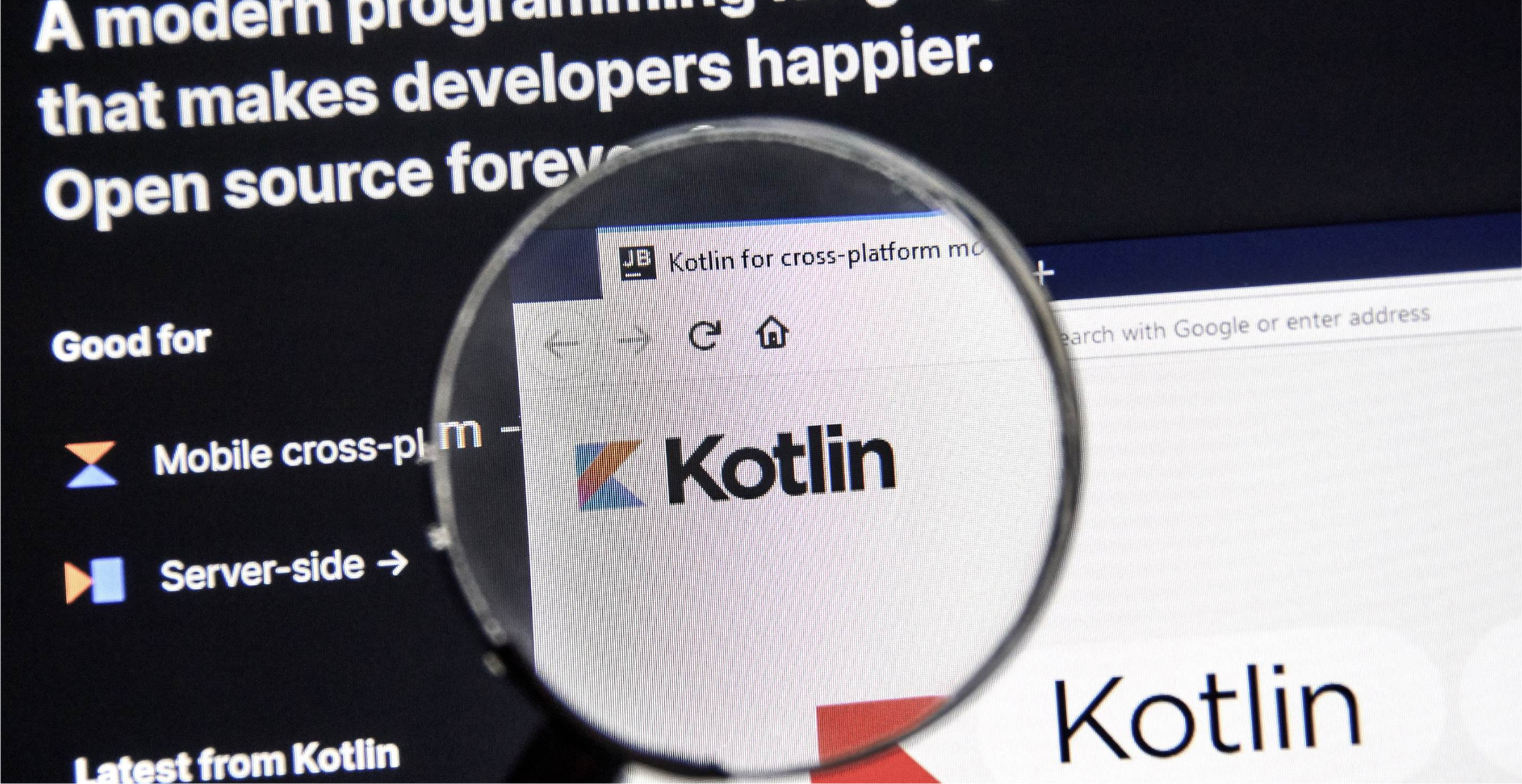 A close-up of a computer screen showing the Kotlin programming language website through a magnifying glass. The screen highlights that Kotlin is a modern, open-source programming language, with emphasis on mobile cross-platform and server-side development. The magnified section focuses on the Kotlin logo, reinforcing its relevance in the developer community. The image represents the importance of Kotlin in modern software development.