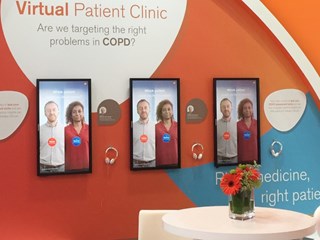 The image shows a display from a "Virtual Patient Clinic" focused on COPD (Chronic Obstructive Pulmonary Disease) with the question, "Are we targeting the right problems in COPD?" There are three digital screens featuring two patients, one labeled "Trevor" and the other "Eunice." Headphones are available below each screen for users to interact with or listen to content. The background includes bright colors and text that discusses personalized medicine and patient-focused care. A small round table with a flower vase is also visible in the foreground.