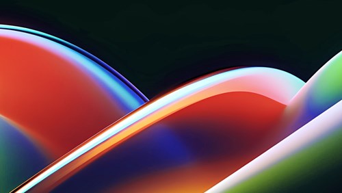 An abstract image featuring smooth, overlapping curved shapes with glossy, reflective surfaces. The colors transition from vibrant reds and oranges on the left to bright yellows, greens, and deep blues on the right.